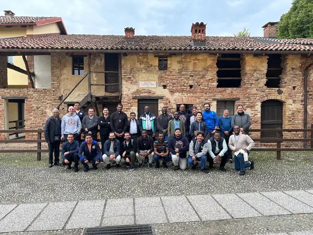 Grupo de salesianos ante una casa de piedra